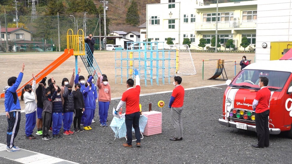 校庭で手をあげる子どもたちの画像