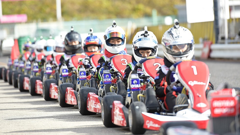 レーシングカートで隊列を組む子供たち