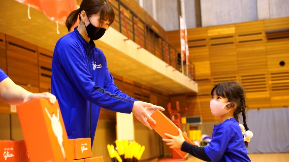 新鍋理沙さんからグリコ商品を受け取る子供の画像